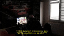 a man in a hat sits in front of a computer screen with the words fortnite on the bottom right
