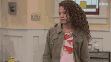 a girl with curly hair is wearing a watermelon shirt