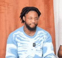 a man with a beard wearing a blue sweater with a skeleton on it .