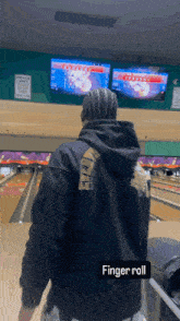 a person in a bowling alley with the word finger roll on the bottom right
