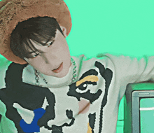 a man wearing a hat and a sweater with a cartoon face on it