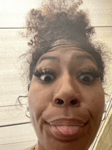 a woman with curly hair making a funny face with her tongue out