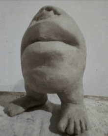 a statue of a frog with a large mouth is sitting on a table