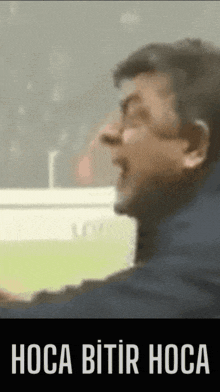 a blurred image of a man with the words " hoca bitir hoca " on the bottom