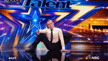a man is on a stage in front of a sign that says talent