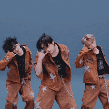 three young men are standing next to each other wearing matching outfits with stars