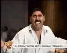 a man with a mustache is holding a hamburger in his hand and smiling .