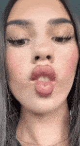 a woman is making a funny face with her tongue sticking out .