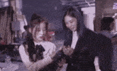 two young women are standing next to each other in a room .