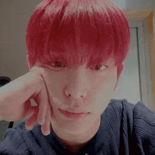 a young man with red hair is looking at the camera