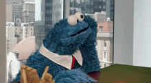 a cookie monster is sitting at a table with his feet up