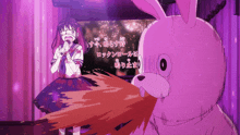 a girl singing into a microphone next to a stuffed animal with chinese writing on it