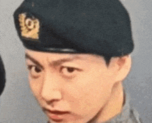 a close up of a man wearing a beret and making a funny face .