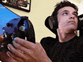 a man wearing headphones is holding a steering wheel in his hands