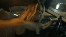 a woman is screaming in a car with max written on the bottom