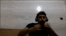 a man wearing headphones is sitting on a couch in a dark room