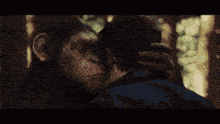a man and a monkey are looking at each other in a dark room
