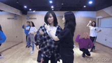 a group of young women are dancing in a dance studio with gifrun.com in the corner