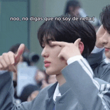 a man in a suit is pointing at his eye with a caption that says noo no digas que no soy de nella .