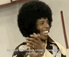 a man with an afro is laughing with the words sly and the family stone concussion protector below him