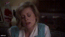 a woman is sitting at a table with her eyes closed in a pixelated image