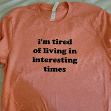 an orange t-shirt that says i 'm tired of living in interesting times