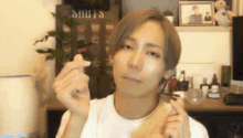 a man is making a heart with his hands in front of a sign that says shots