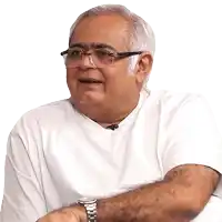 a man wearing glasses and a white shirt has a watch on his left wrist