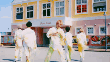 a group of people are dancing in front of a building that says ocean bizun