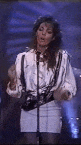 a woman is standing in front of a microphone on a stage .