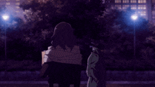 a man with a bag around his neck is standing in front of a street light at night