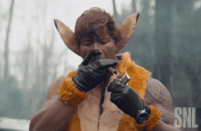 a man in a fox costume is smoking a cigarette with the snl logo in the background