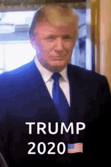 a man in a suit and tie is standing in front of a window and says trump 2020 .