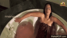 a woman is laying in a bathtub with a towel around her neck .