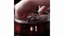 a person is putting chocolate pieces into a bowl .