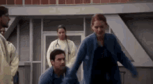 a group of doctors and nurses are standing around a man in a hospital room .