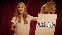 a woman holding a piece of paper that says hello on it