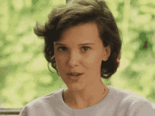 a close up of a woman 's face wearing a blue shirt .