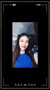 a woman in a blue shirt is being recorded on a cellphone