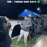 a group of people are standing in a line with the words thr : tarian hari raya on the bottom