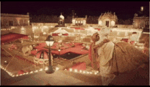 a bride and groom are kissing in front of a decorated courtyard .
