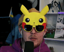 a man wearing sunglasses and a pikachu mask talks into a microphone