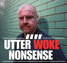 a man leaning against a green brick wall with utter woke nonsense