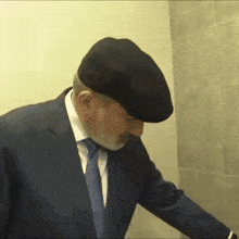 a man in a suit and hat is standing in a bathroom