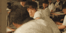 a group of people are sitting in a classroom .