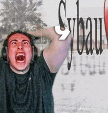 a man wearing headphones is screaming in front of a sybau sign
