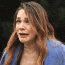 a woman with long hair is making a funny face with her mouth open .