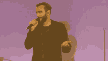 a man singing into a microphone with his hands outstretched