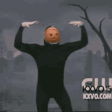 a man with a pumpkin on his head is giving a thumbs up sign