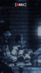 a recording of a person standing in a dark room with a red rec button